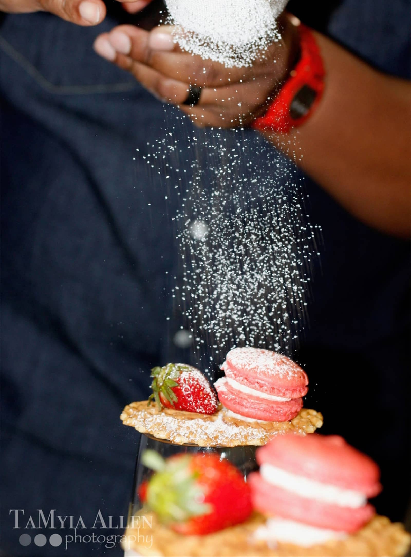 White Powder falling onto pink macaroons and strawberry desserts